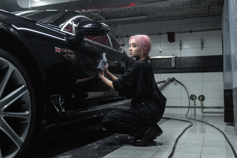 Professional auto detailing worker focused on precision cleaning